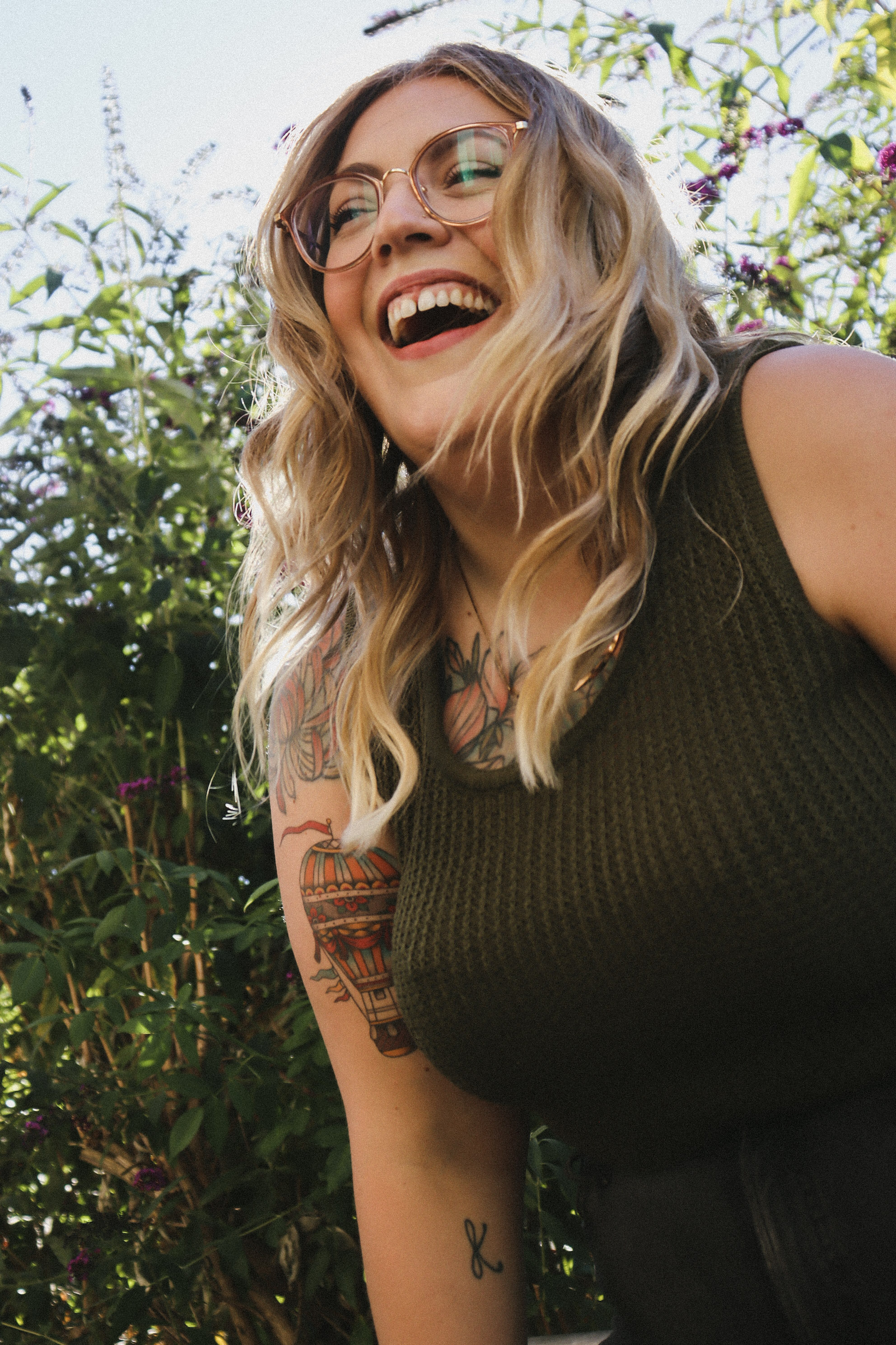 Karli smiling outdoors, wearing glasses and a sleeveless top