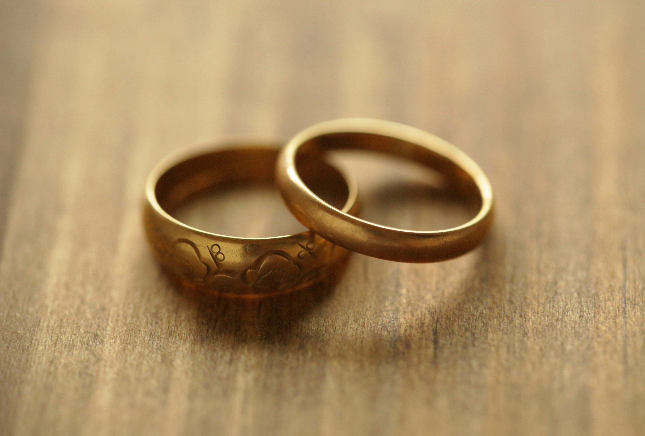 Two wedding bands on a wooden surface
