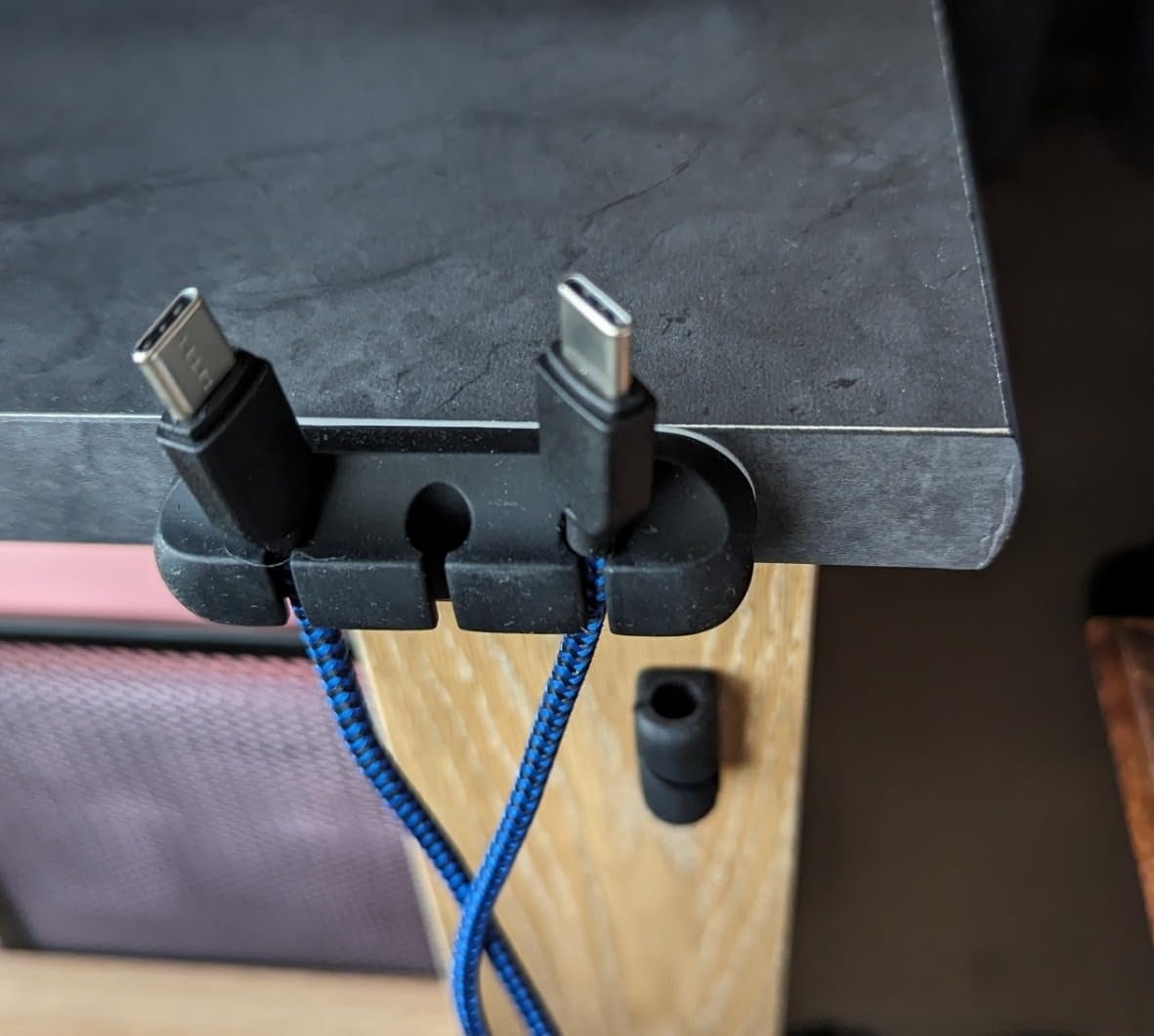 a reviewer photo of two charging cables with USB-C connectors organized on desk edge