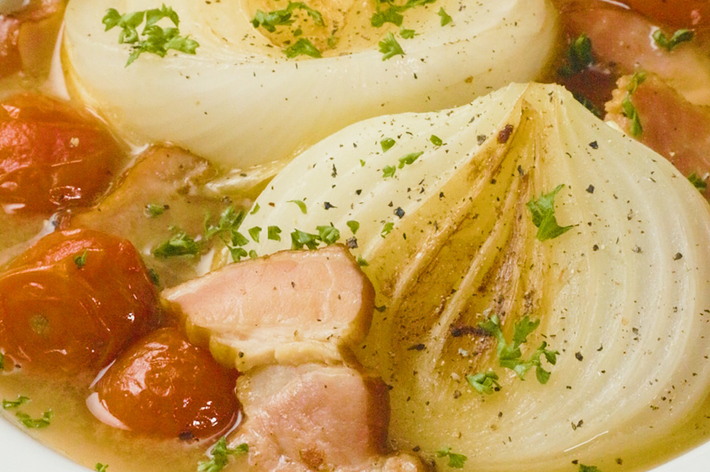 たまねぎとトマト、ベーコンが入ったスープの写真です。