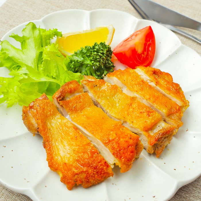 皿に盛られたチキンステーキと野菜。