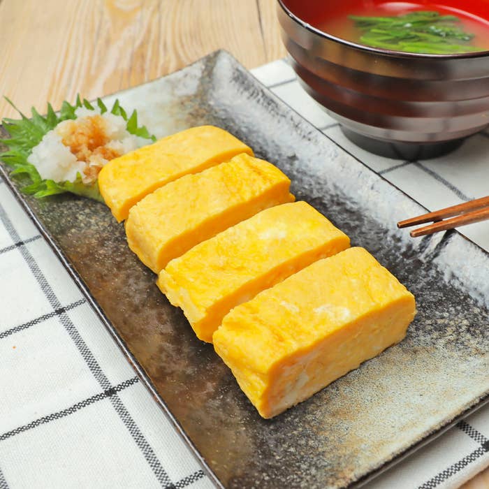 卵焼きが皿に並べられ、味噌汁が添えられた和食の料理写真です。