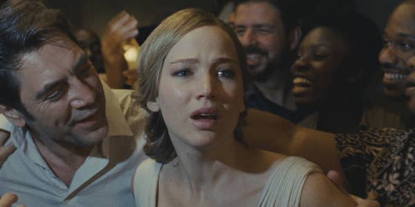 Jennifer Lawrence appears distressed among celebrating people in a movie scene