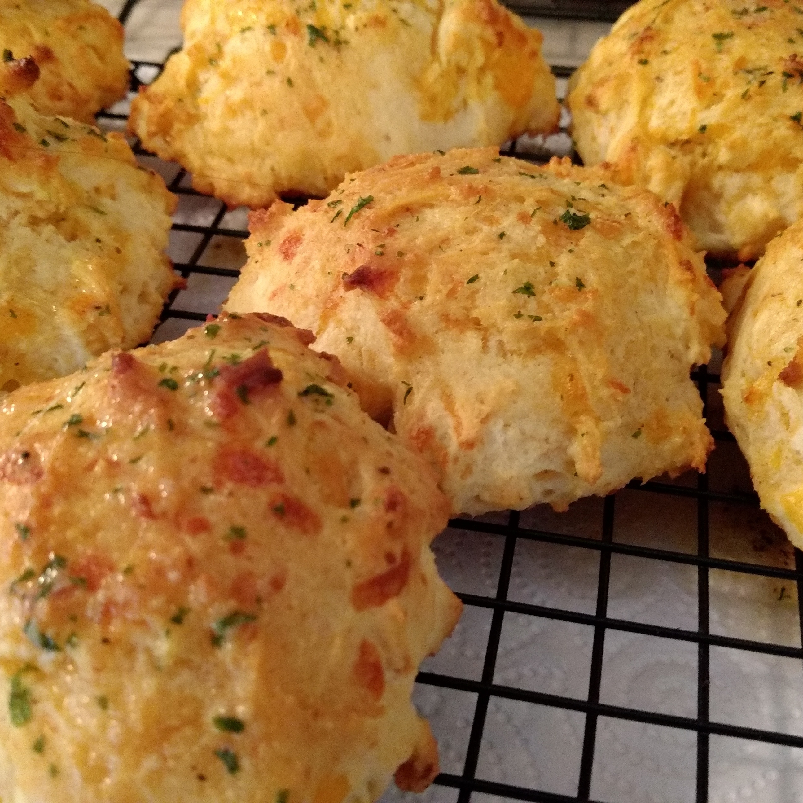 Freshly baked biscuits on a cooling rack, sprinkled with herbs