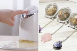 A person's finger pressing a modern white automatic soap dispenser; tea infusers beside gemstone decorations on wood surface