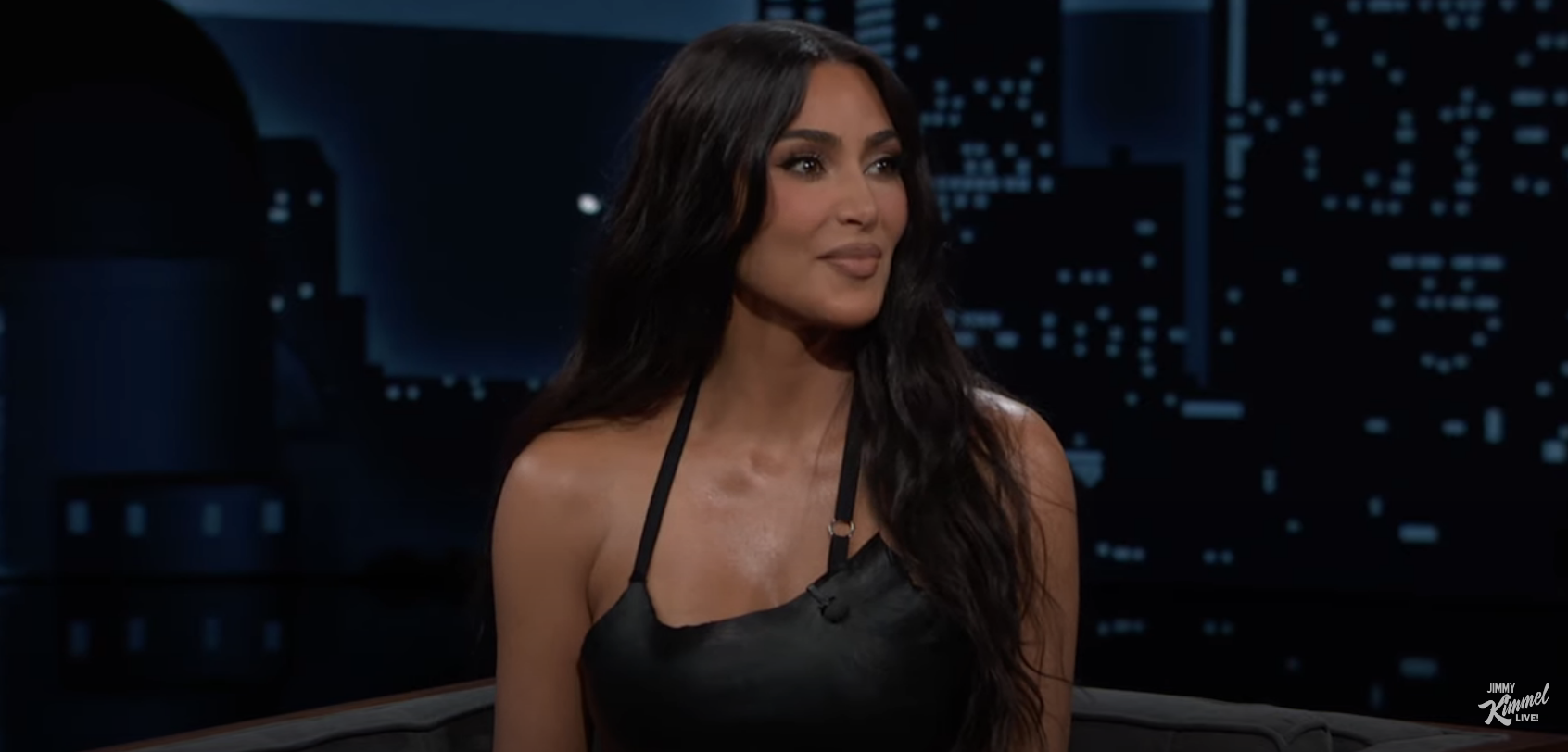 Kim Kardashian wearing a black top, seated during a TV interview