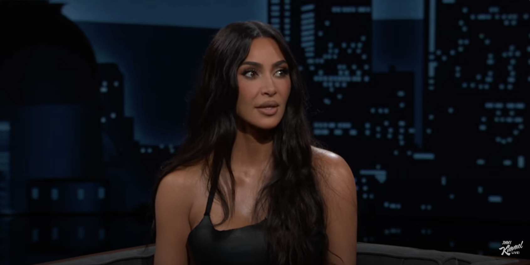 Kim Kardashian in a sleek top, seated on a TV show set
