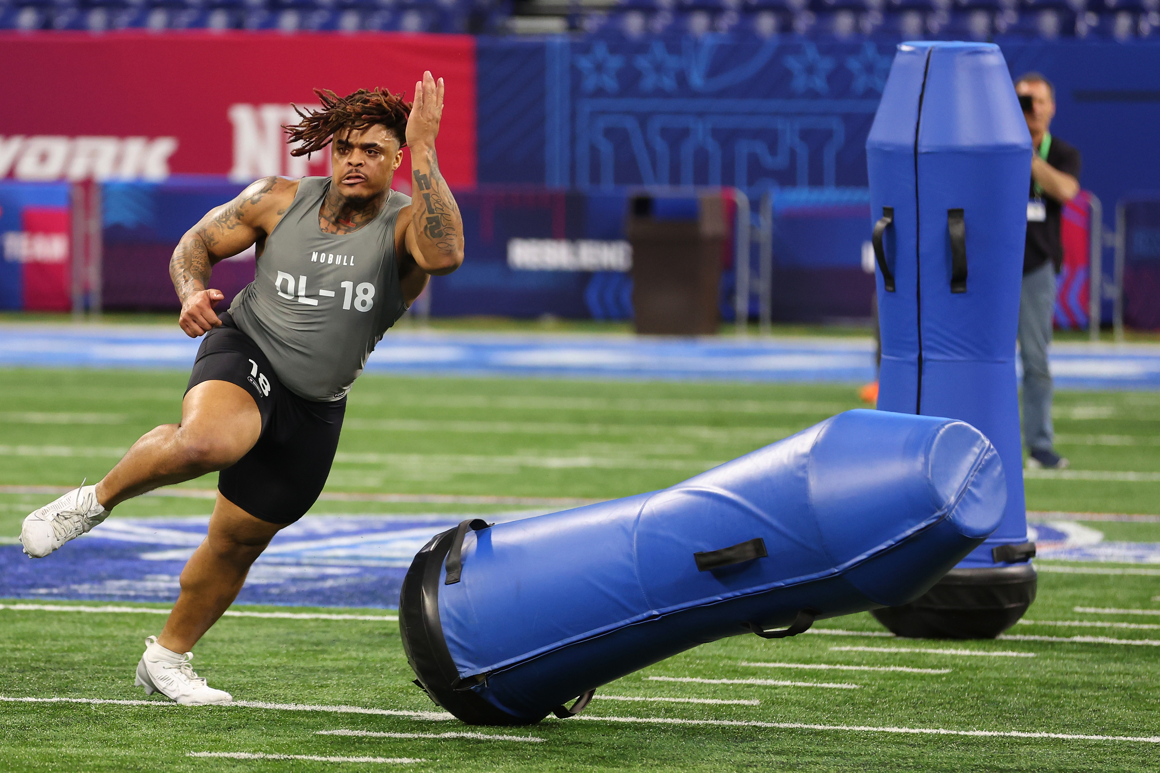 Athlete in action during a football agility drill with equipment on the field