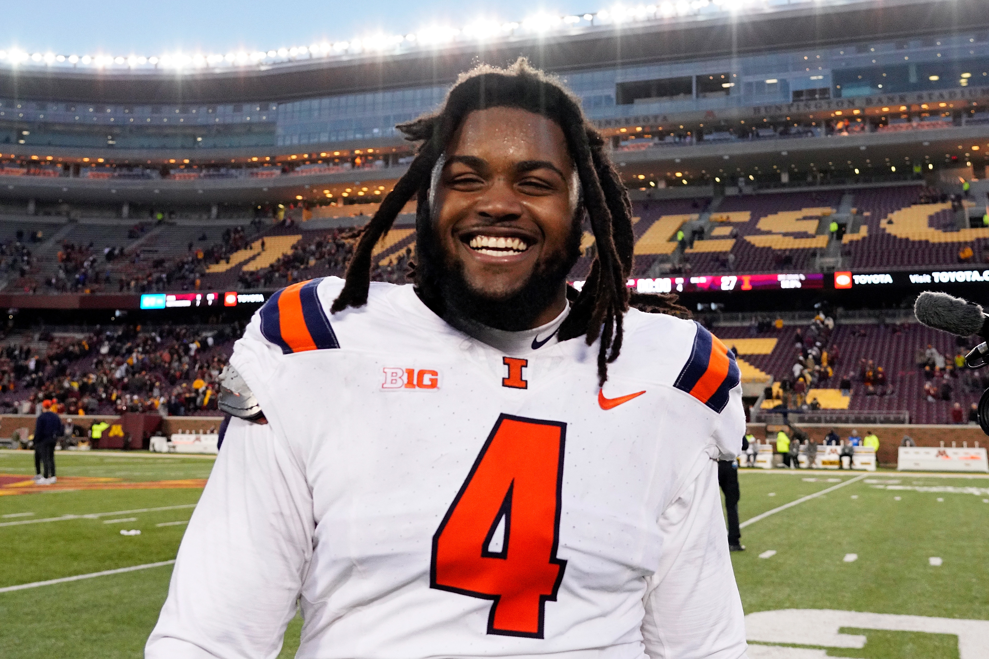 Smiling football player on field wearing an &quot;Illini&quot; jersey with the number 4, after a game