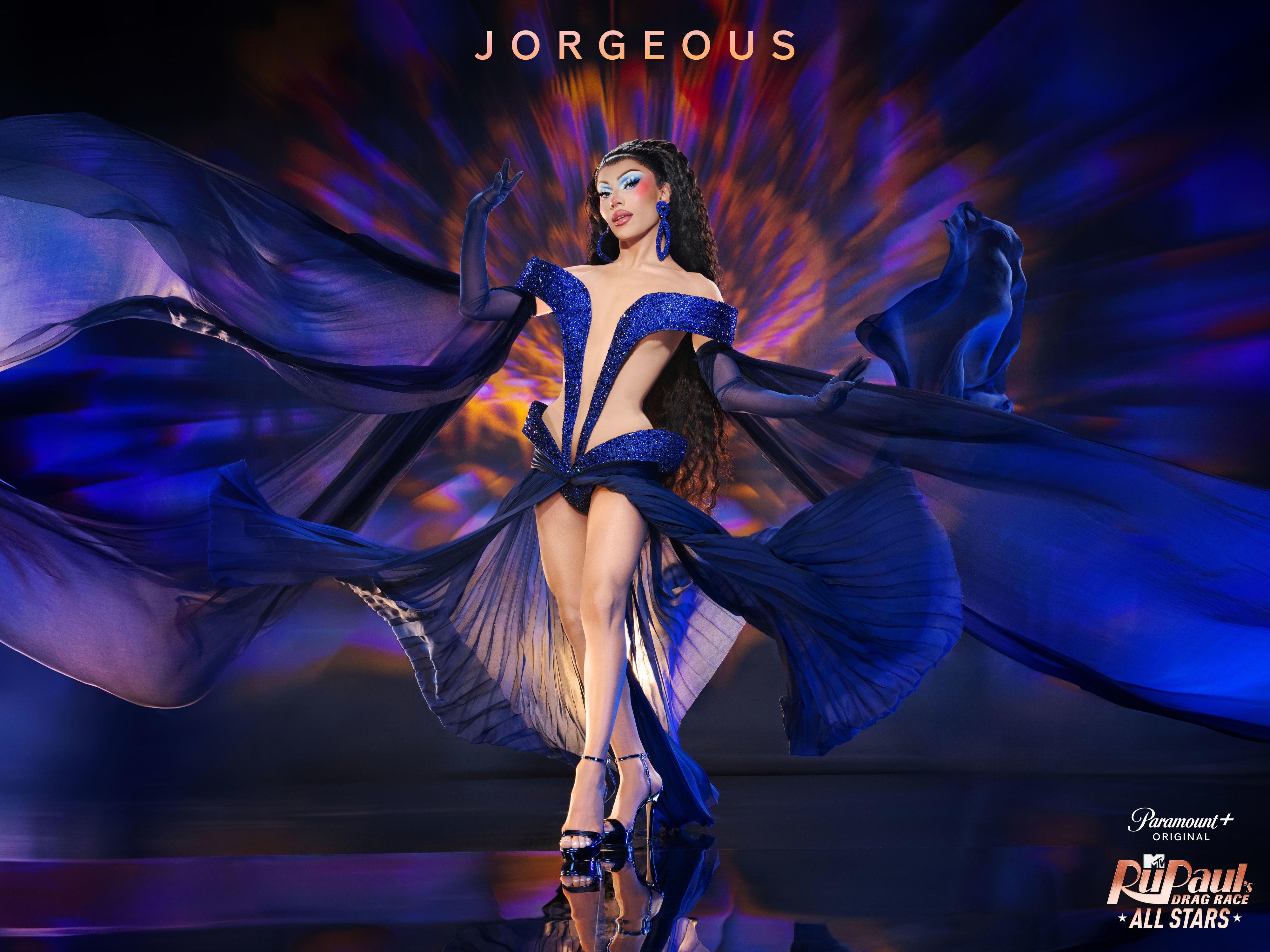 Jorgeous in an elaborate blue costume with expansive flowing fabric