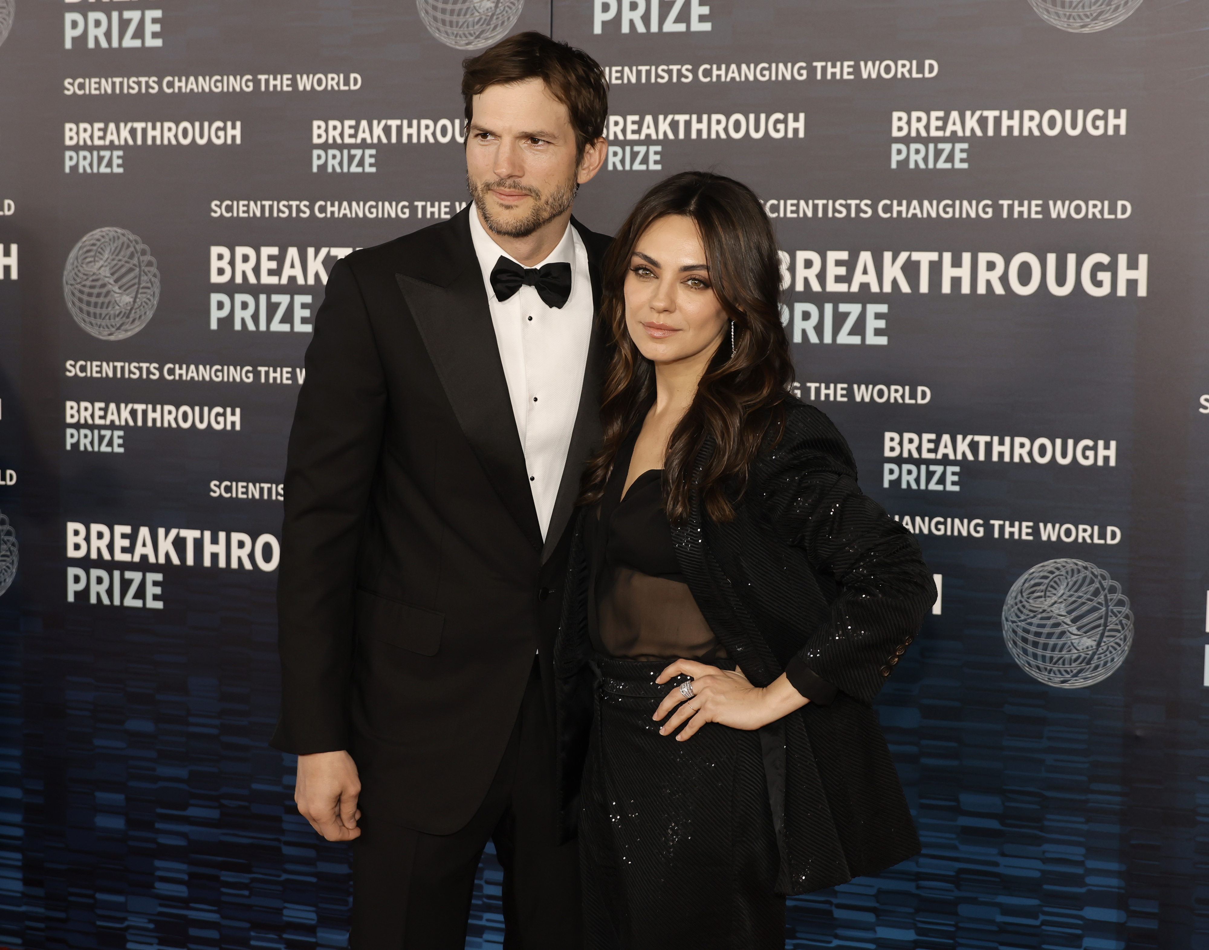 Ashton Kutcher and Mila Kunis posing together at the Breakthrough Prize event
