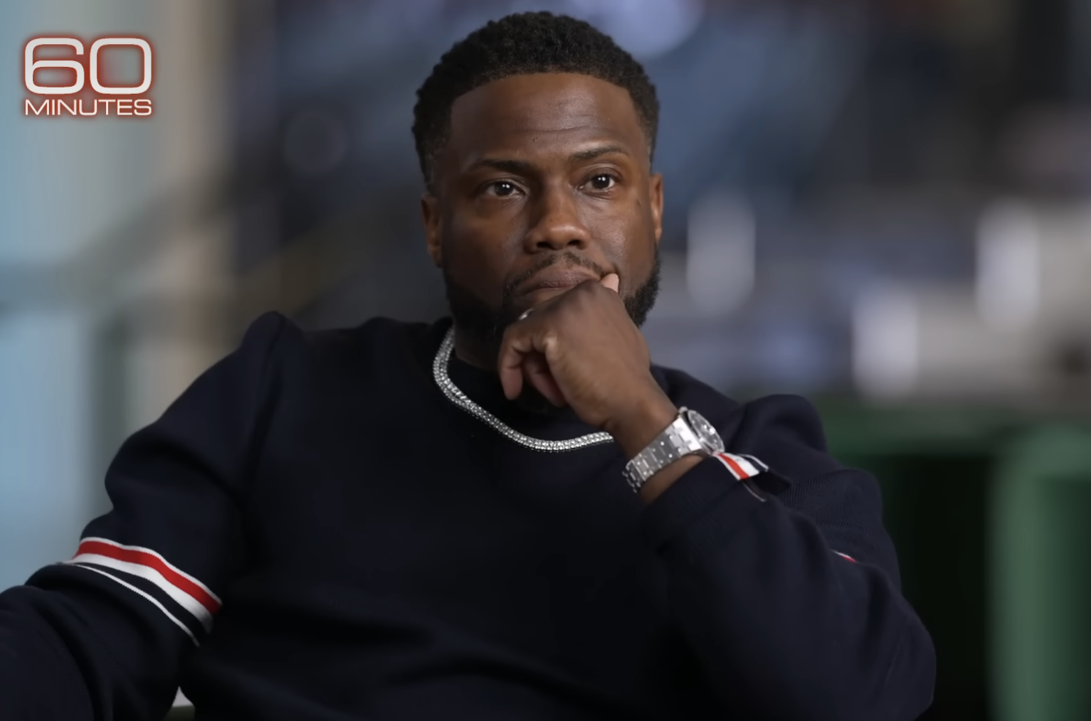 Kevin Hart in a striped sweater sits for an interview on 60 Minutes