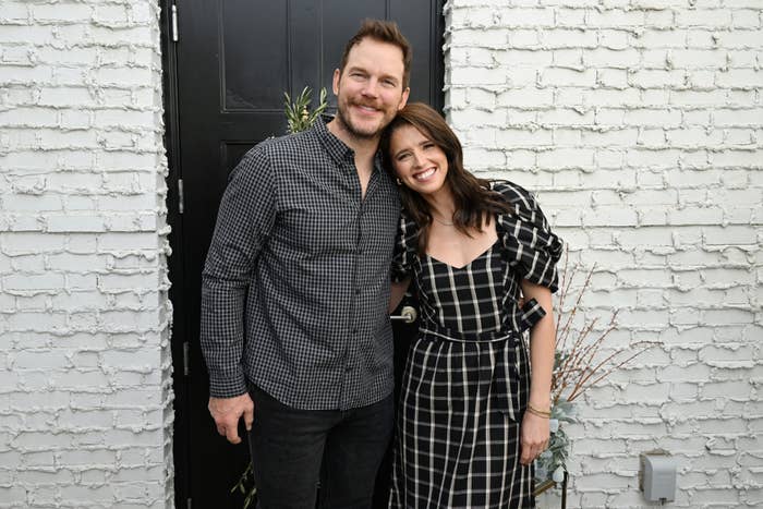 Chris Pratt and Katherine Schwarzenegger smiling as they stand outside in front of a door