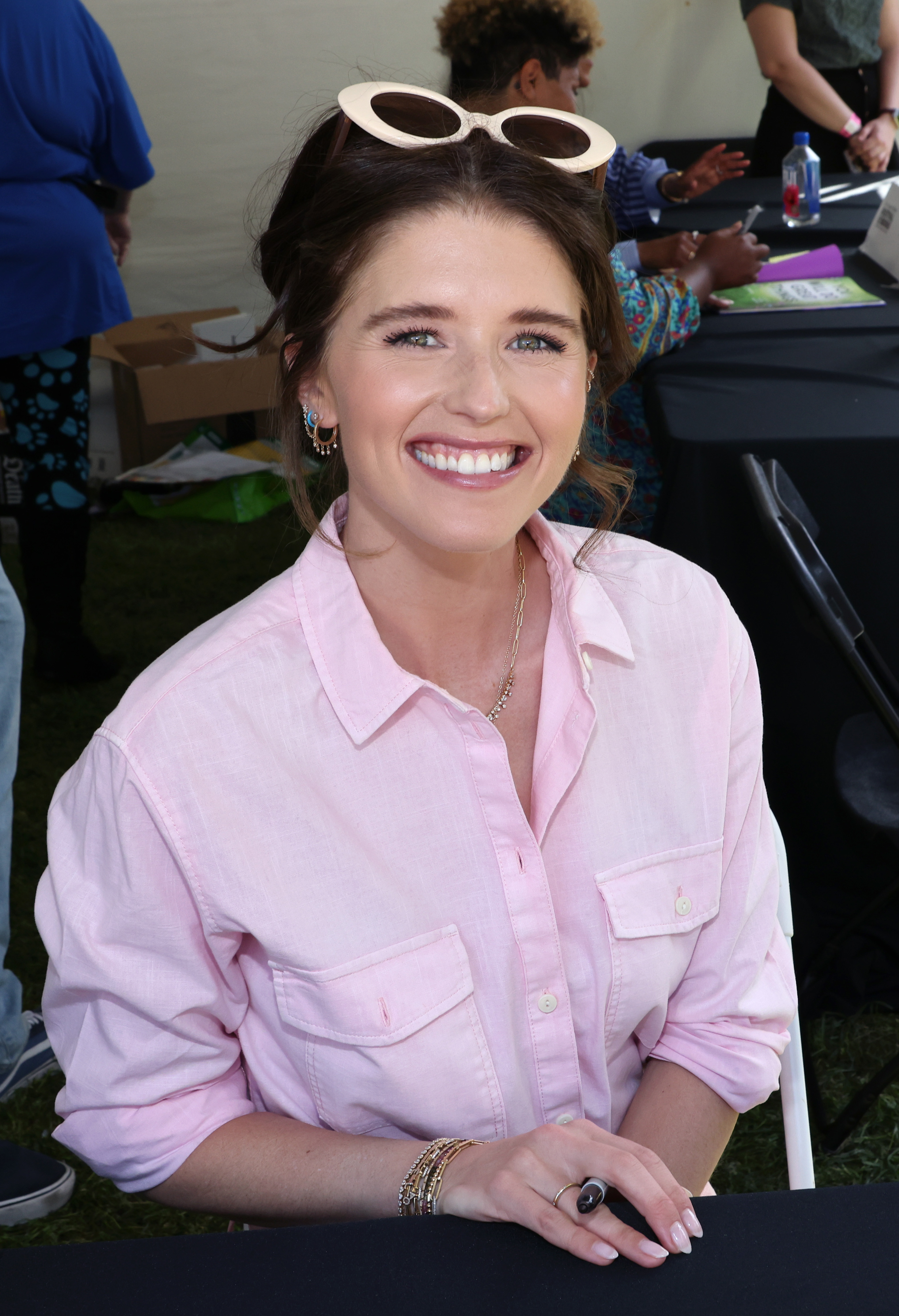 A closeup of Katherine Schwarzenegger smiling and holding a pen in her hand