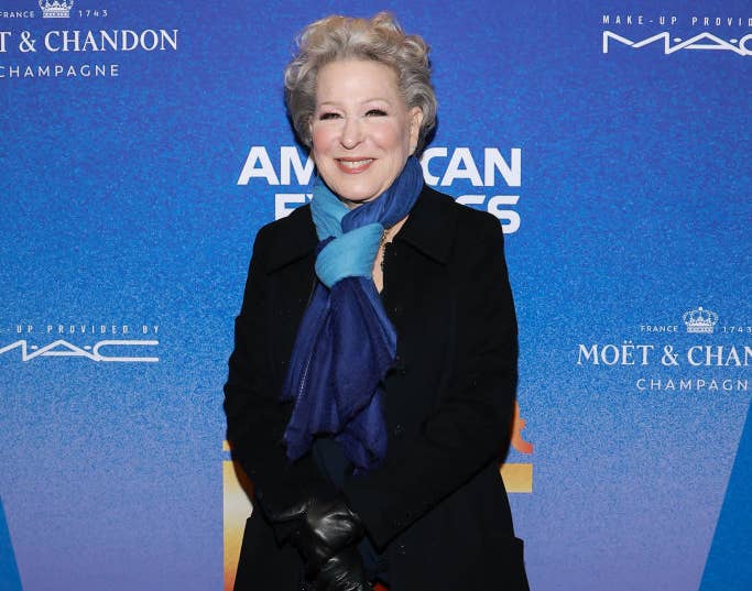 Bette Midler at an event wearing a coat, scarf, and gloves