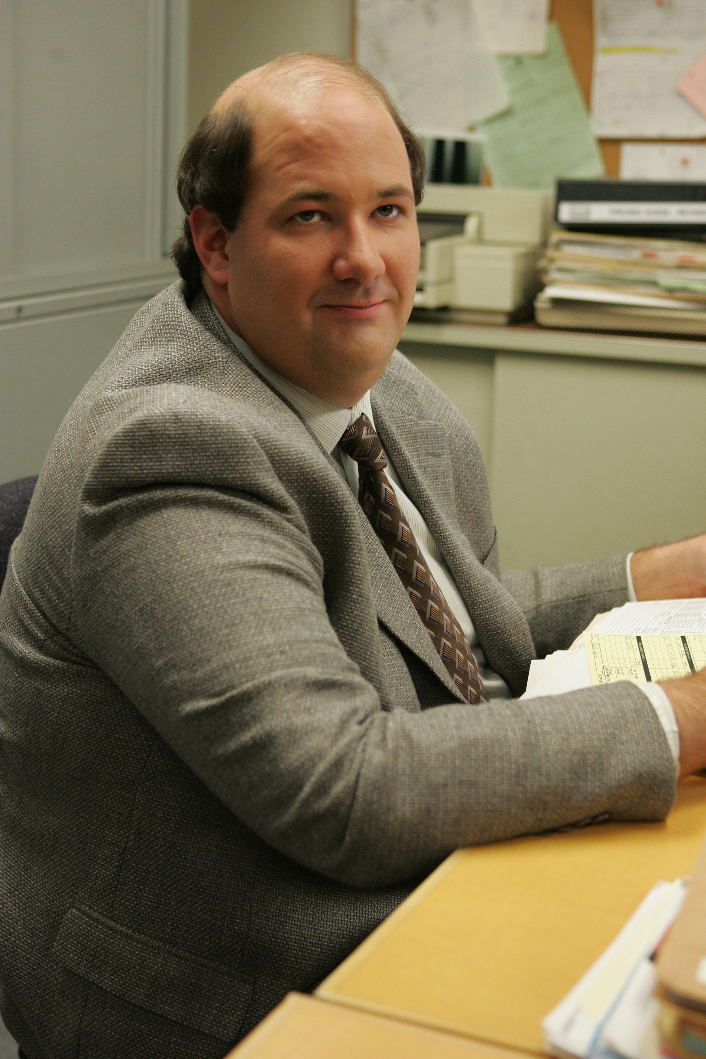 Man in a business suit sitting at a desk in an office environment