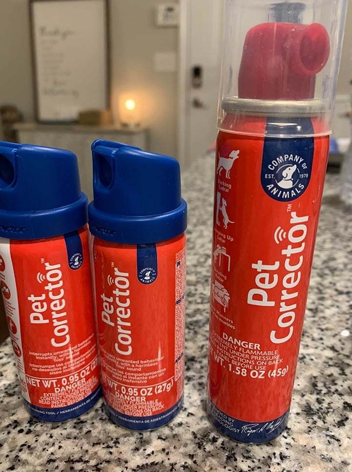 Three Pet Corrector spray cans on a countertop