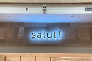 店舗の壁に「salut!」のネオンサイン。