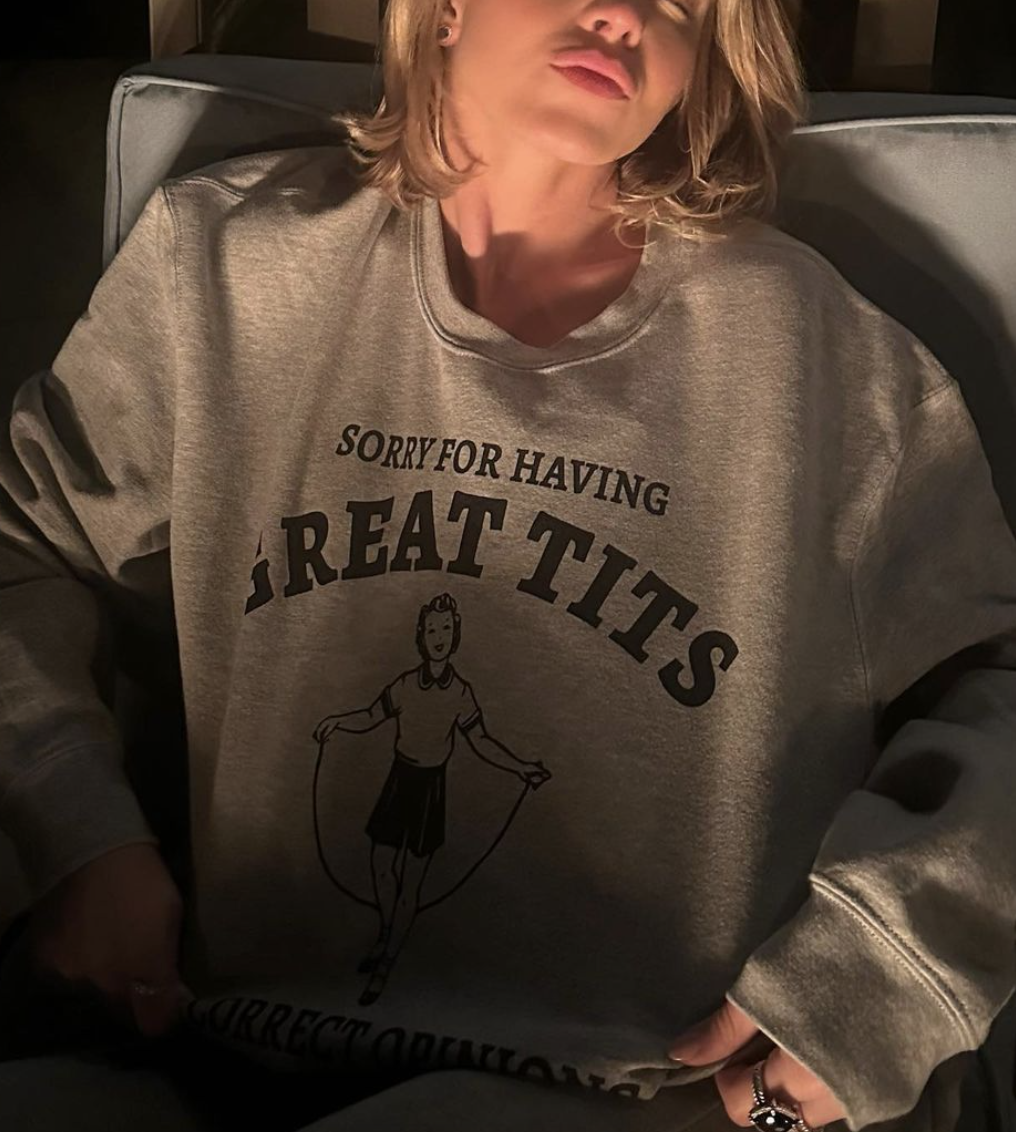 Person in a graphic sweatshirt with text &quot;SORRY FOR HAVING GREAT TITS&quot; and a cartoon figure