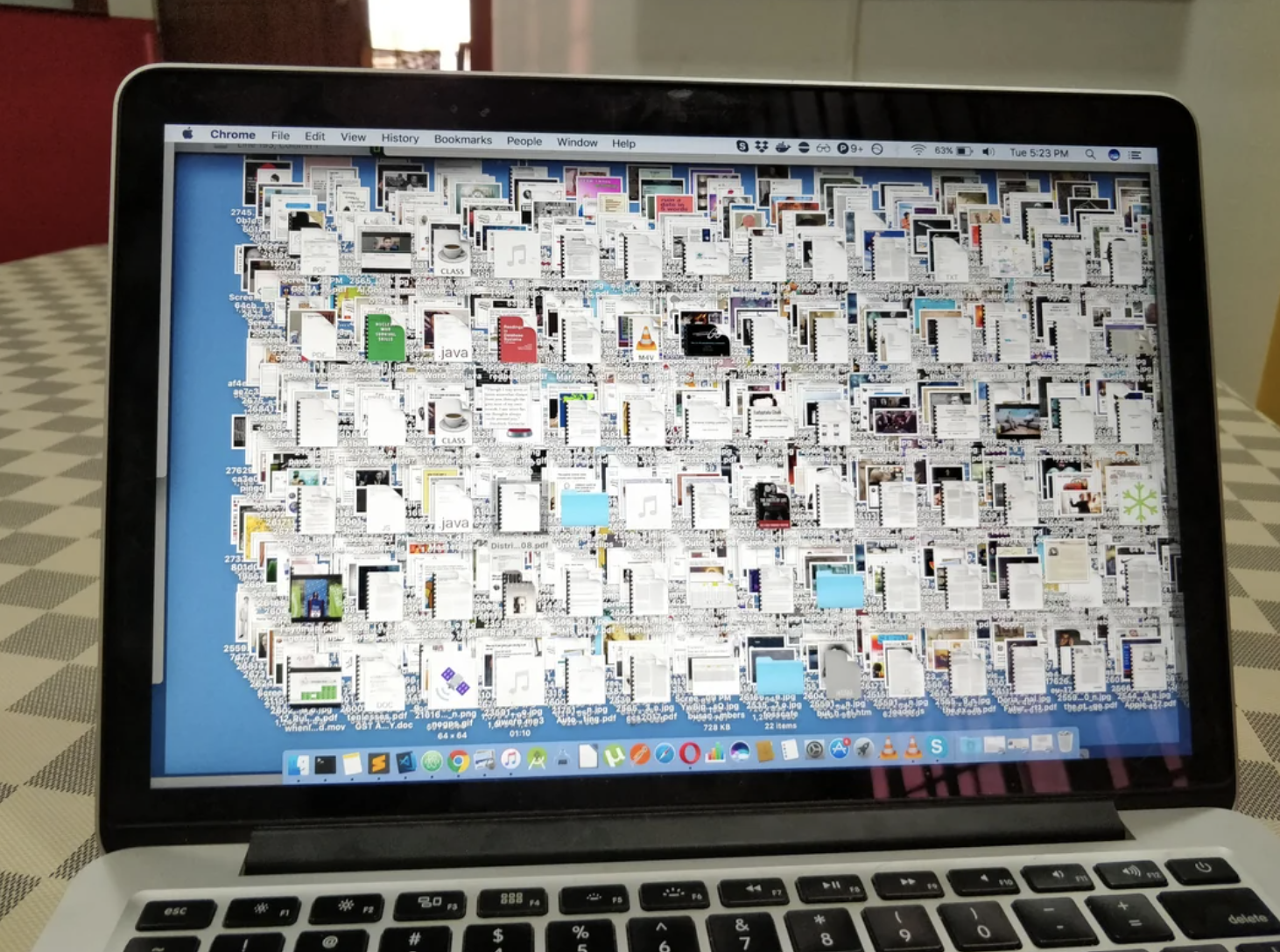 Laptop screen showing an extremely cluttered desktop with numerous overlapping files and folders