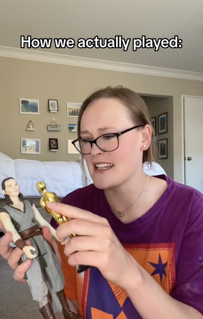 Alexa smiling and holding action figures of Rey from Star Wars and a mini Oscar statuette