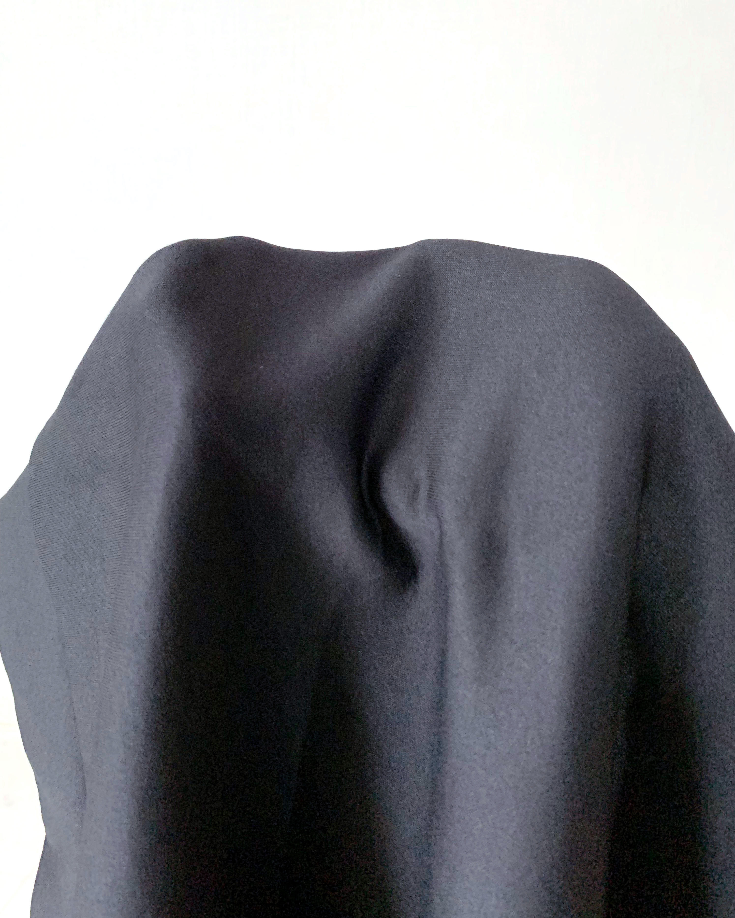 Person concealed under a plain fabric, obscuring identity and form