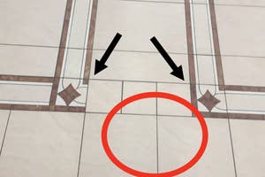 Floor with a pattern, marked by arrows pointing to a flaw circled in red