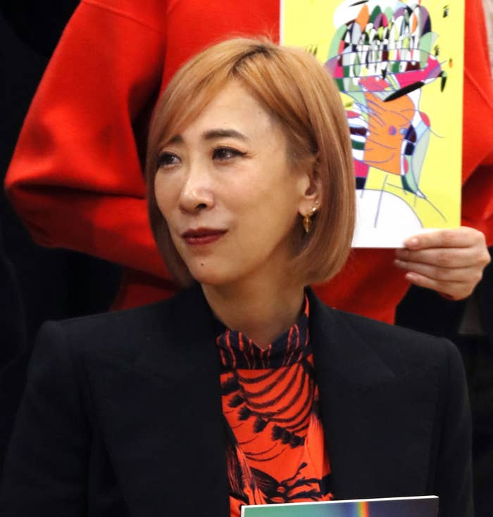 赤いジャケットを着た女性がカメラを見て微笑んでいます。