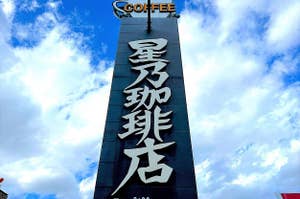Signage for a coffee shop with large Chinese characters, under a partly cloudy sky. Small text indicates hours of operation