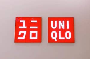 Two square signs with "UNIQLO" logo, one in Japanese and one in English, on a wall