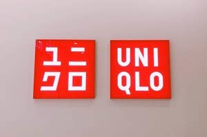 Two signs with logos, one says "UNIQLO" in English, the other in Japanese characters