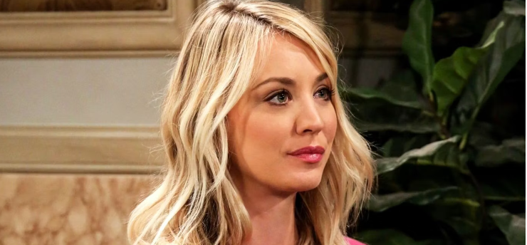 Actress in a TV show set, wearing a formal top, with a pensive expression