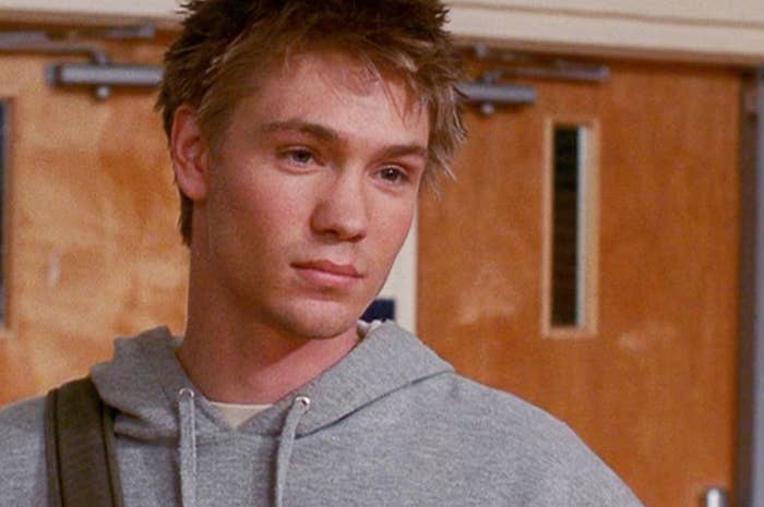 Chad Michael Murray in a grey hoodie, portraying a character in a school hallway scene
