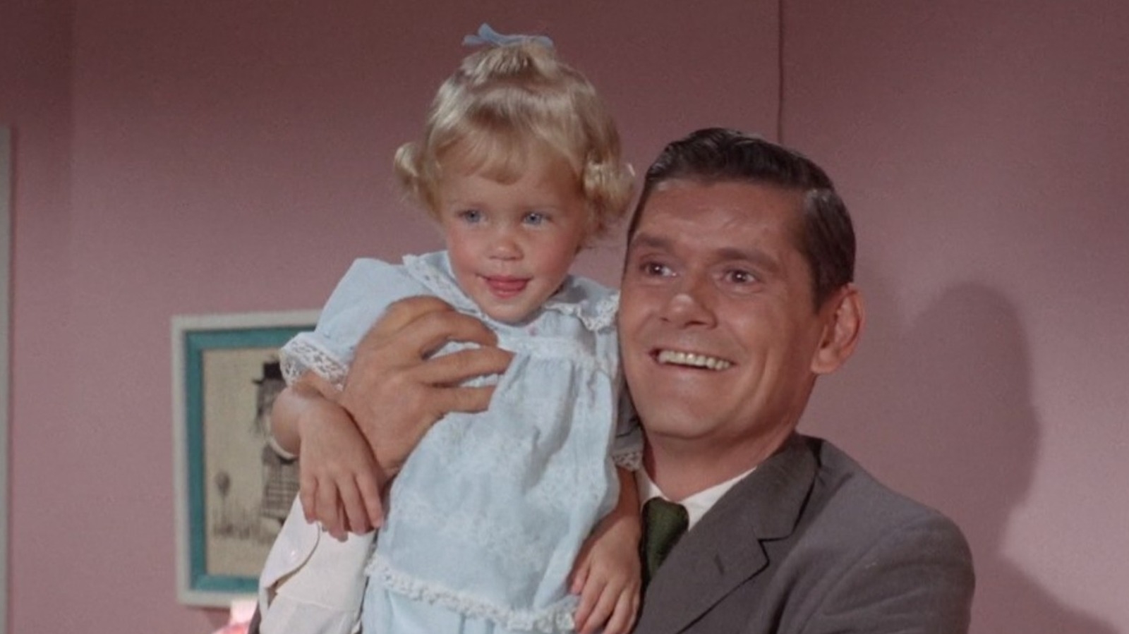 Man holding young child, both smiling, in a scene from a classic TV show