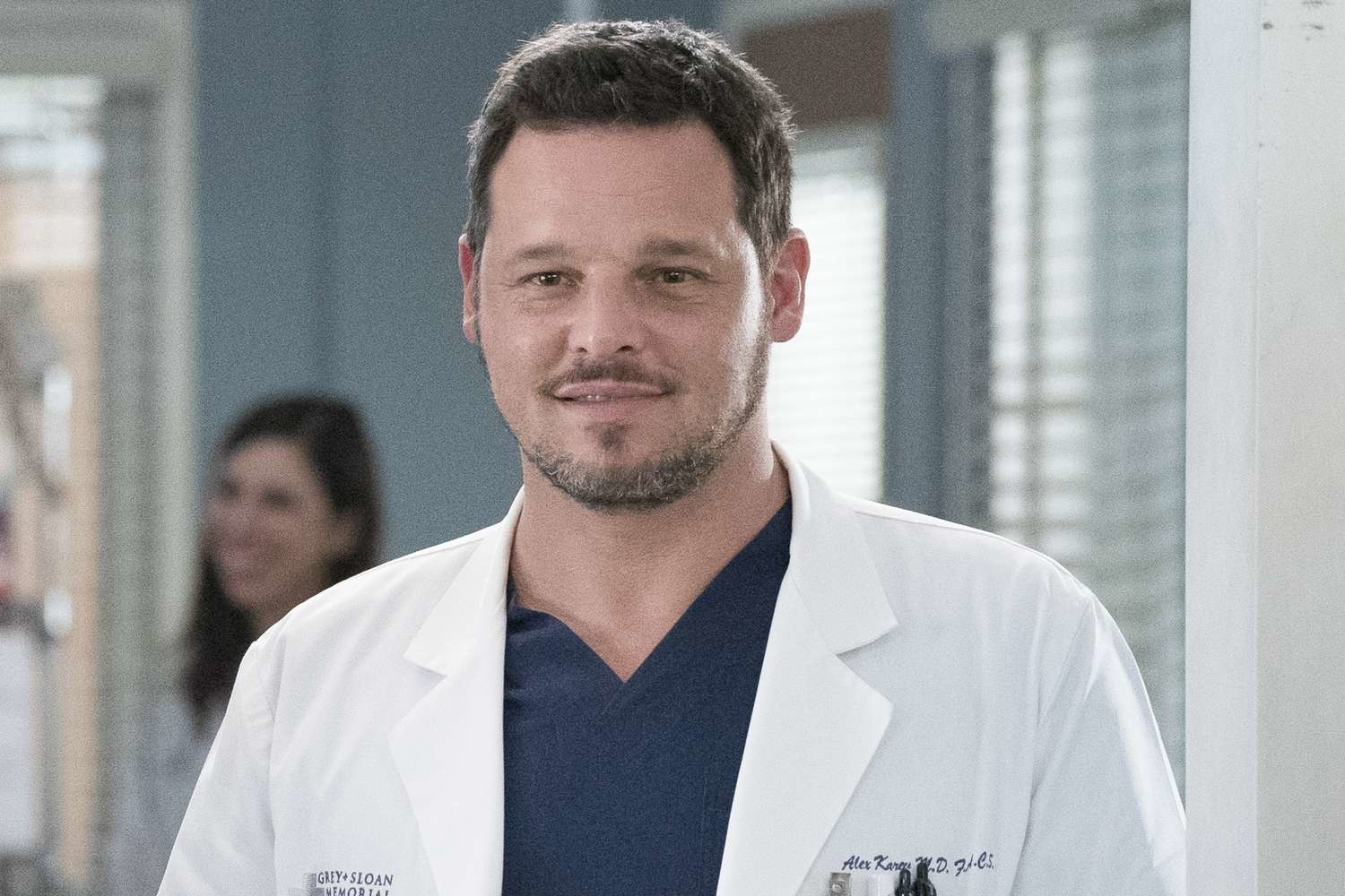 TV character, Dr. Alex Karev from the show, in medical attire, standing in a hospital setting