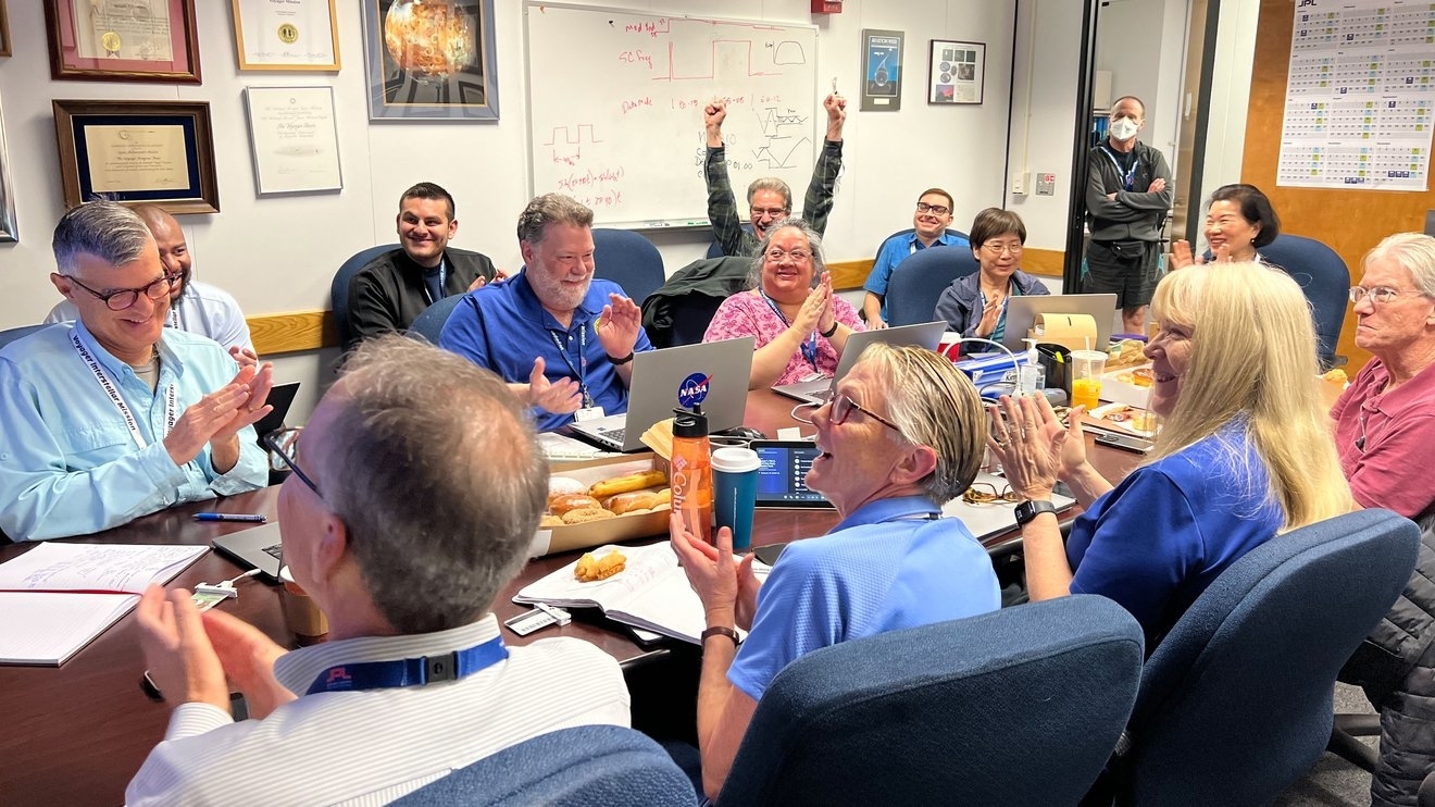 5カ月ぶりにボイジャー1号の健康状態と状態に関するデータを受け取った後、4月20日、NASAのジェット推進研究所の会議室でボイジャー飛行チームのメンバーが祝賀会を開く様子（NASA/JPL-Caltech）