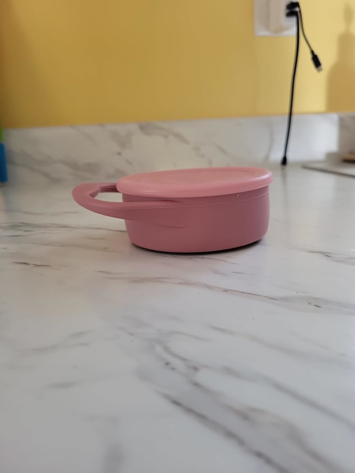 Round pinkish  instrumentality  with a grip  connected  a marble counter, suitable for storing tiny  items