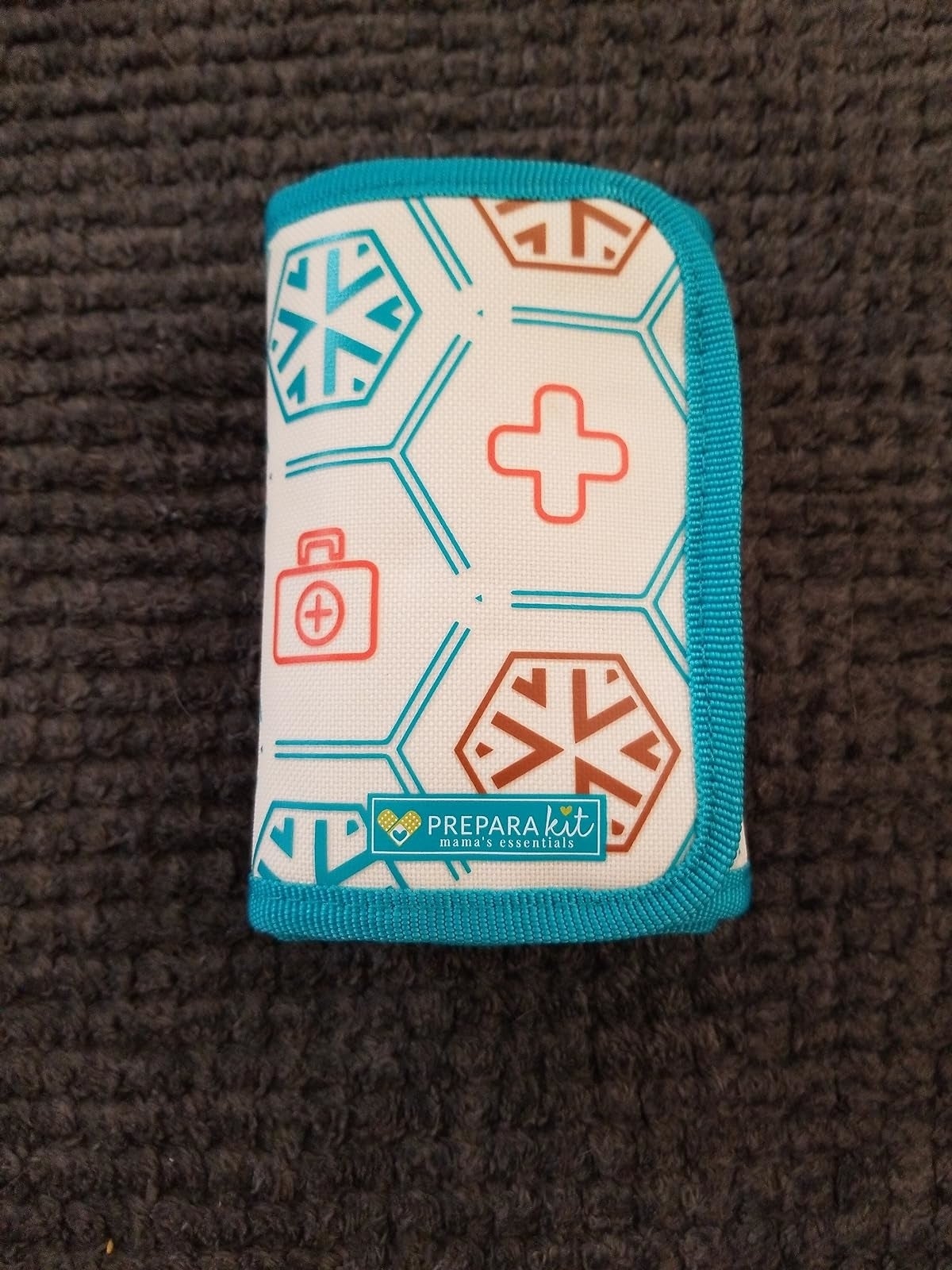 A compact first-aid kit with chiseled  geometric patterns and the PreparaKit logo