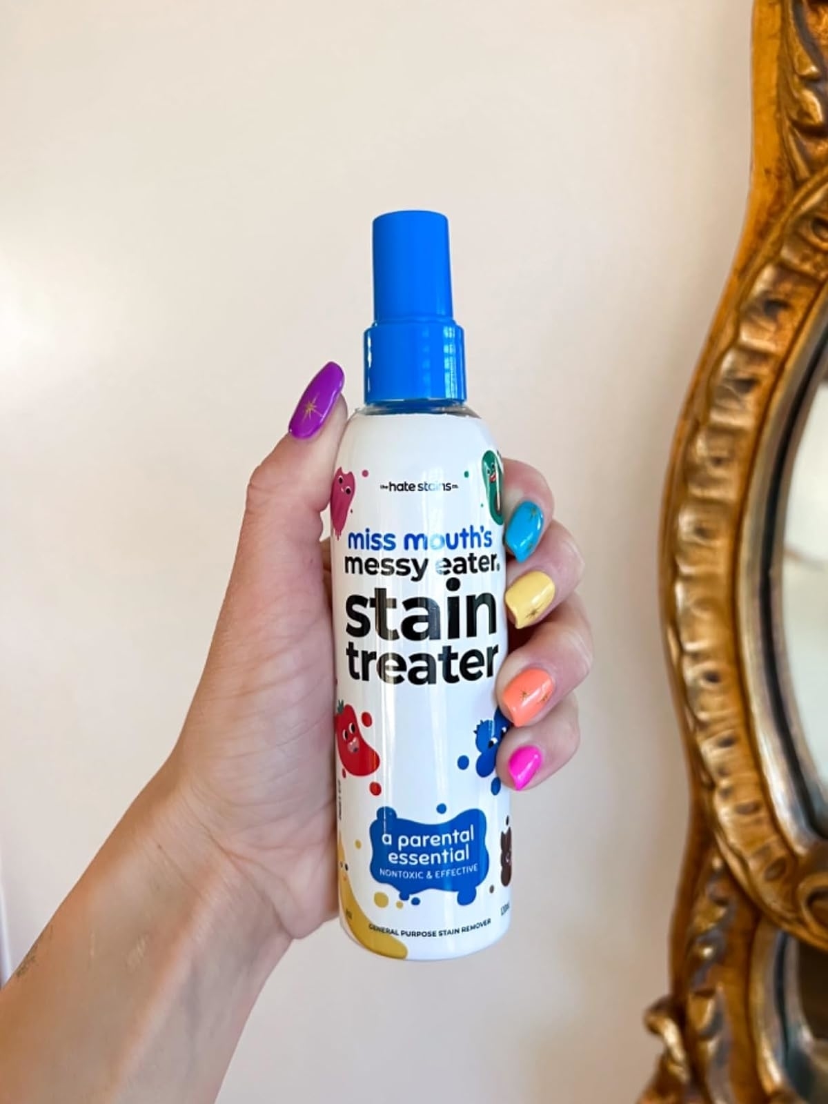 Hand holding a Miss Mouth’s Messy Eater Stain Treater spray bottle