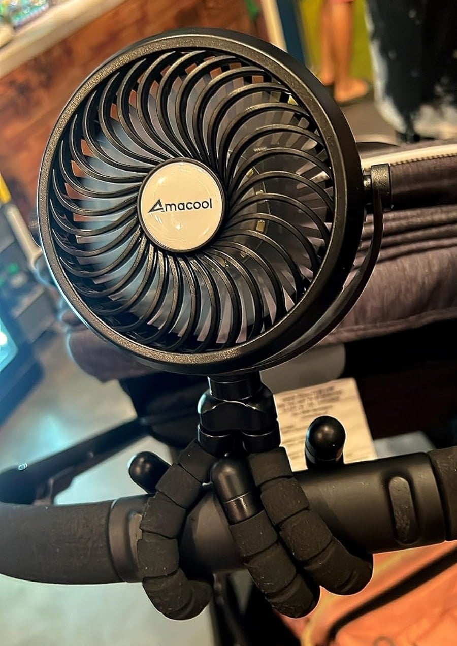 Portable Amacool fan attached to a stroller handle in a store setting