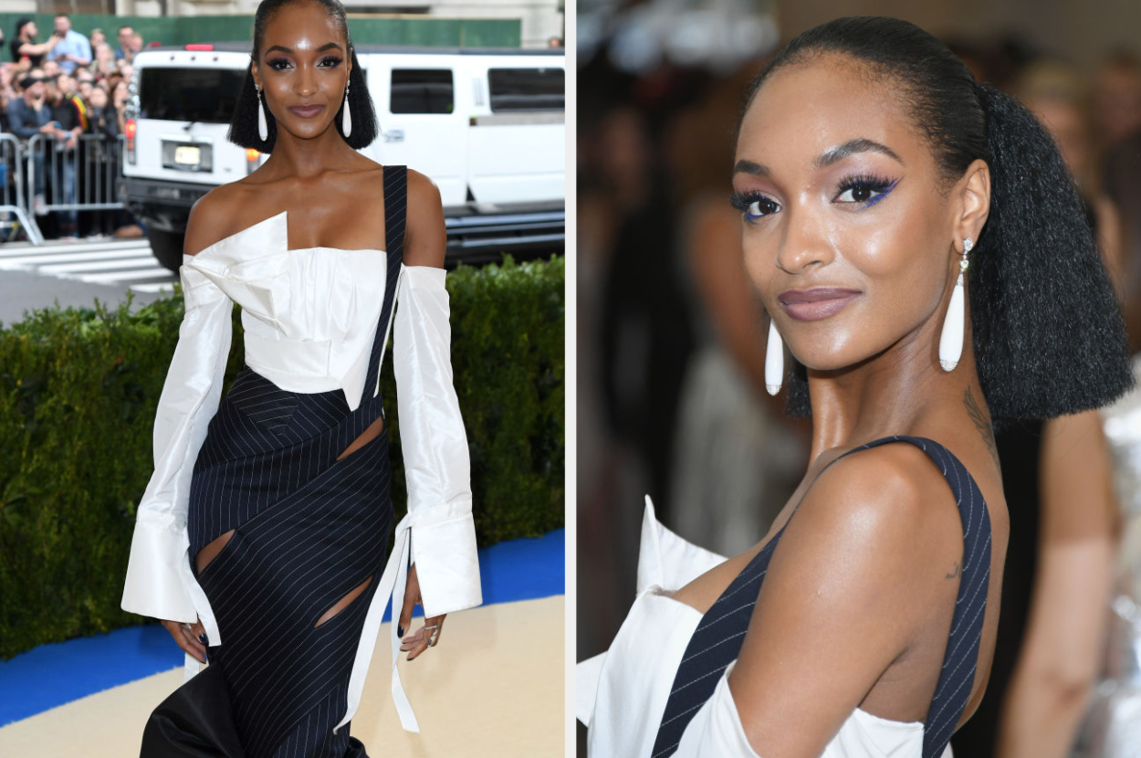Jourdan Dunn at an event in a white top with a black pinstripe skirt, looking at the camera