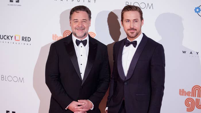 Two men in black tuxedos standing side by side on a red carpet event