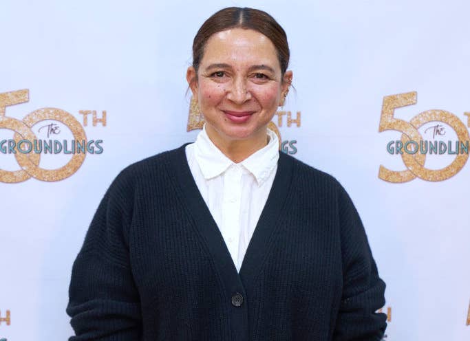 Maya Rudolph posing in a white shirt and black cardigan at The Groundlings event