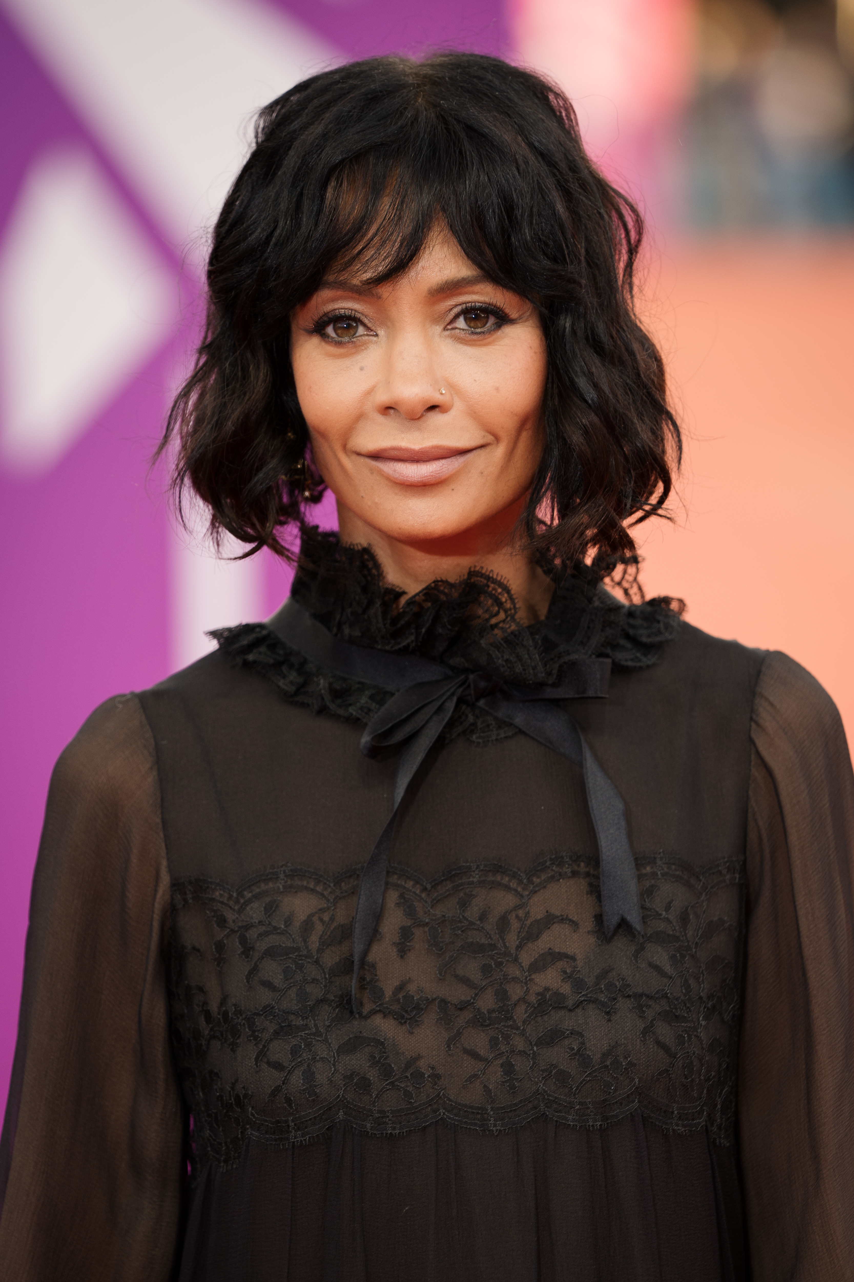 Thandiwe Newton in a sheer black outfit with ruffle detail, posing at an event