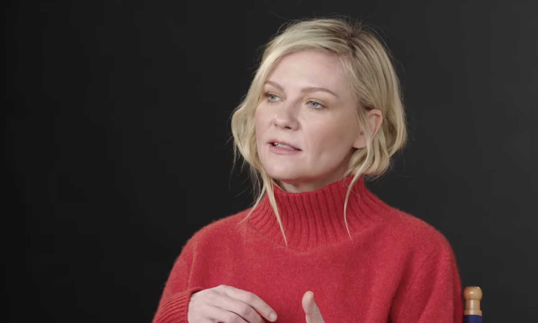 Kristen Dunst in a red turtleneck, discussing a role, in a Youtube video screenshot