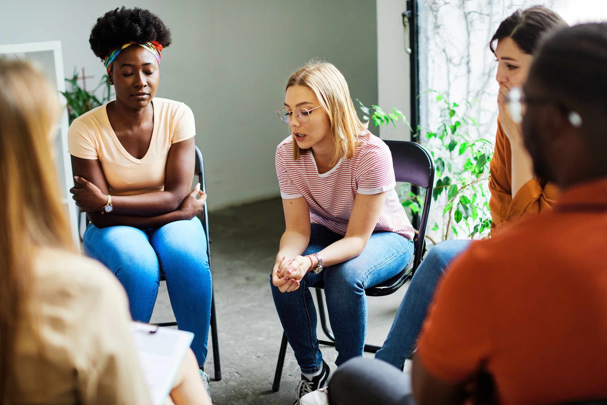 Group of adults in a discussion circle, likely in a workshop or support group setting