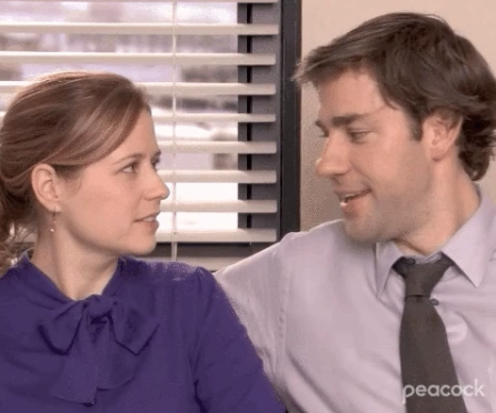 Jim Halpert and Pam Beesly from The Office sitting close, looking at each other affectionately