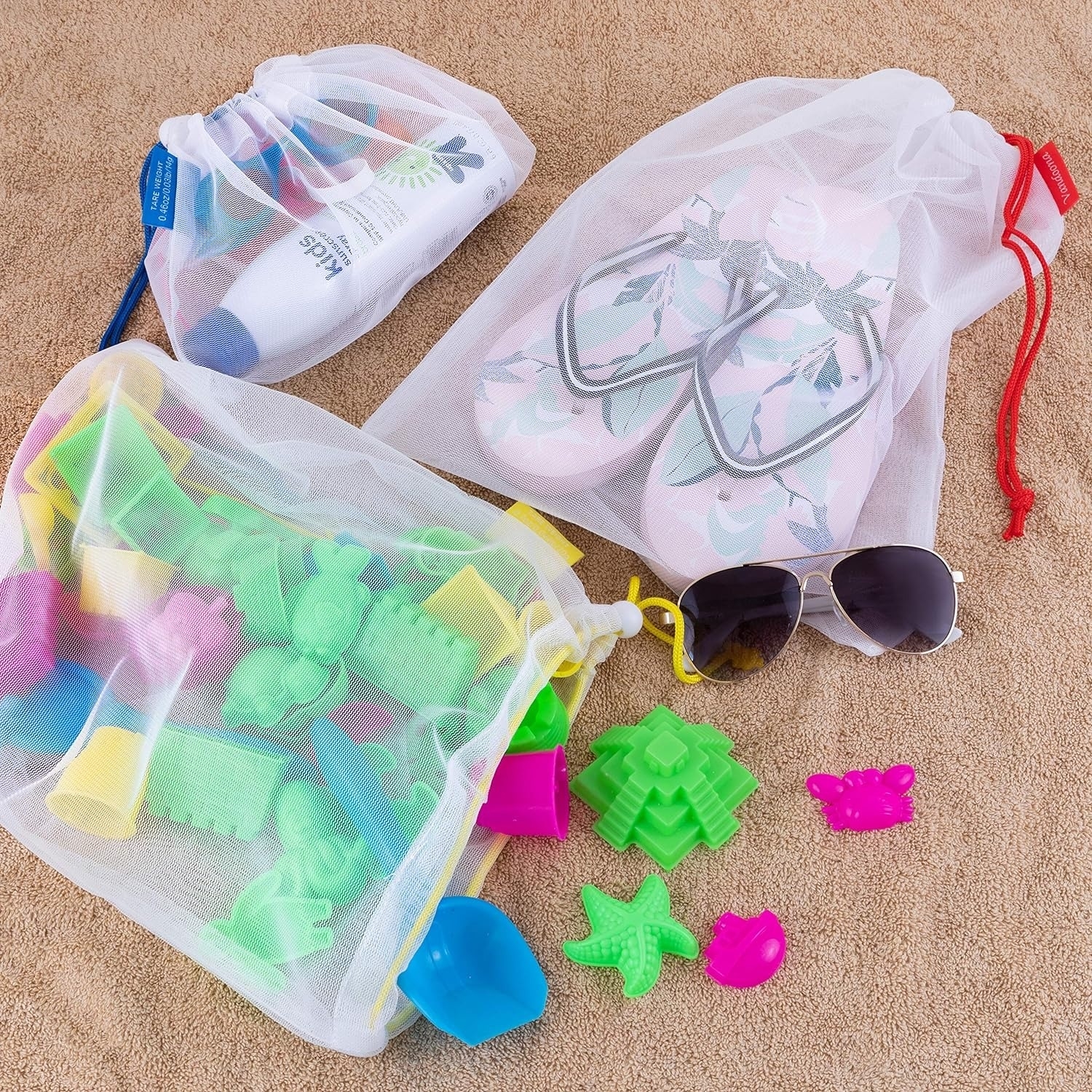 Beach essentials with mesh bags, flip-flops, sunglasses, and assorted sand toys