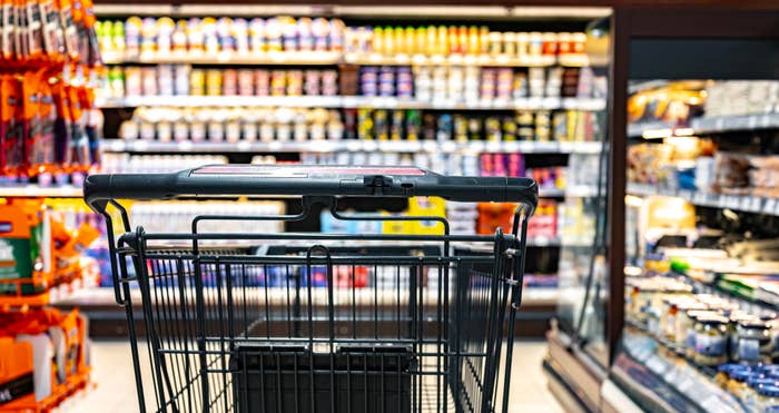 Shopping cart view with grocery store aisles blurred in background