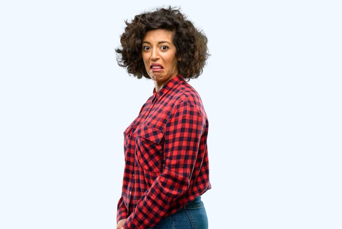 Woman in a plaid shirt making a disgusted expression